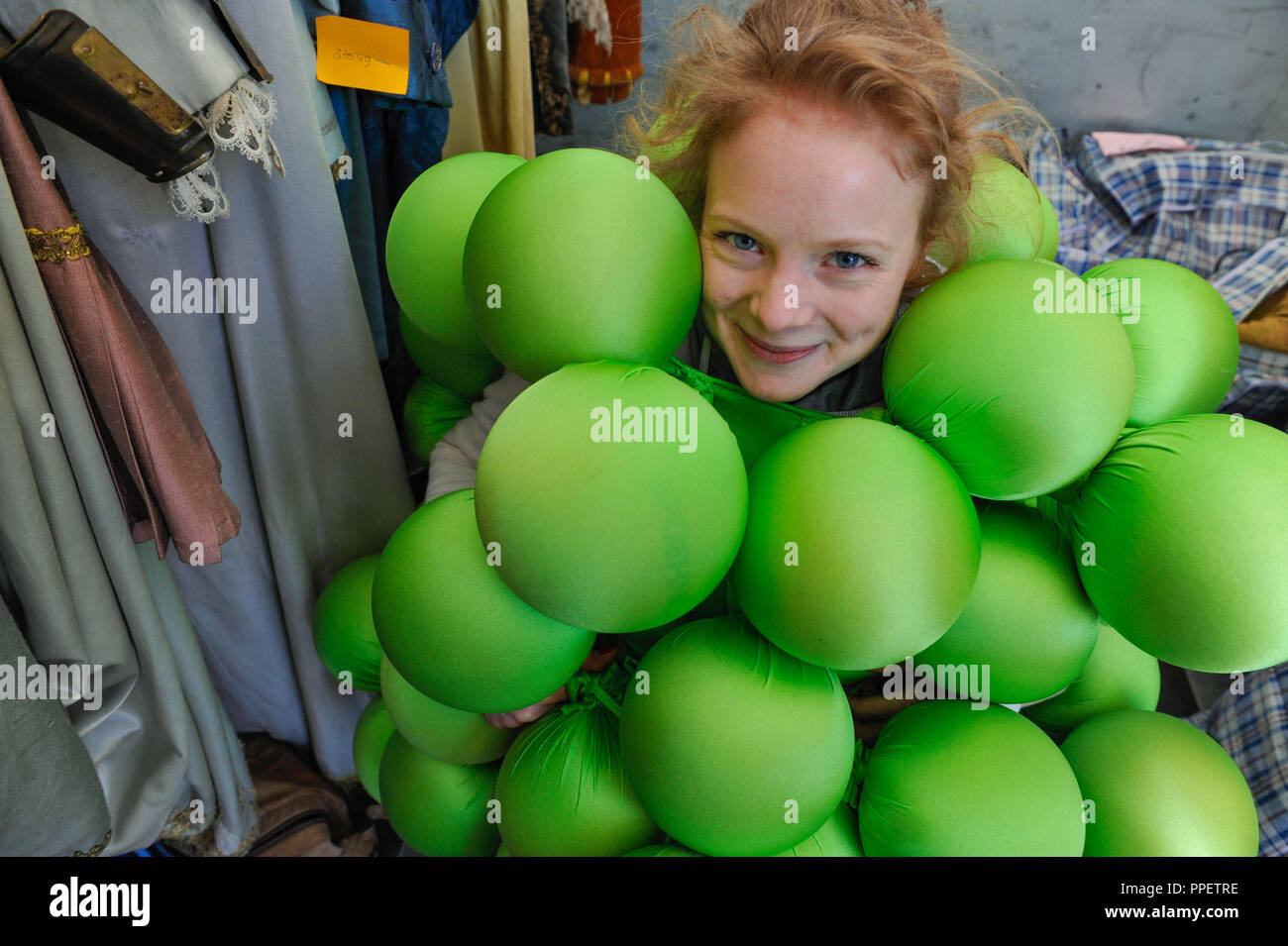 Actress Friederike Ott presents a grape costume at an auction at the theatre flea market on Marstallplatz. The Munich Residenz Theater sells props and costumes from its collection. Stock Photo