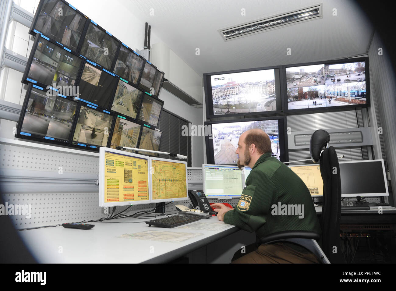 A police officer monitors the happenings at train stations and public places in the video surveillance room of the Operations Centre at the Munich Police Headquarters. Stock Photo