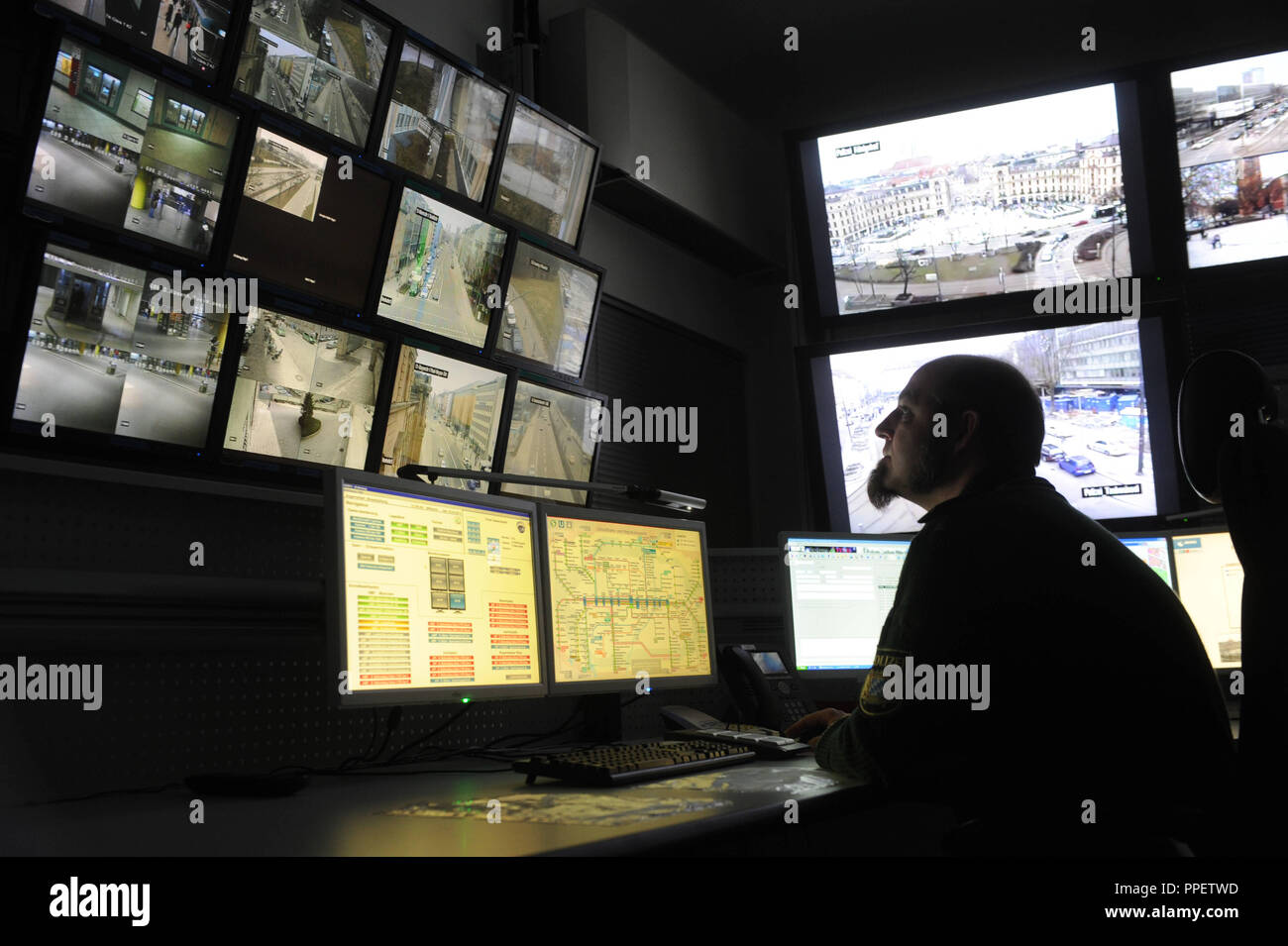 A police officer monitors the happenings at train stations and public places in the video surveillance room of the Operations Centre at the Munich Police Headquarters. Stock Photo