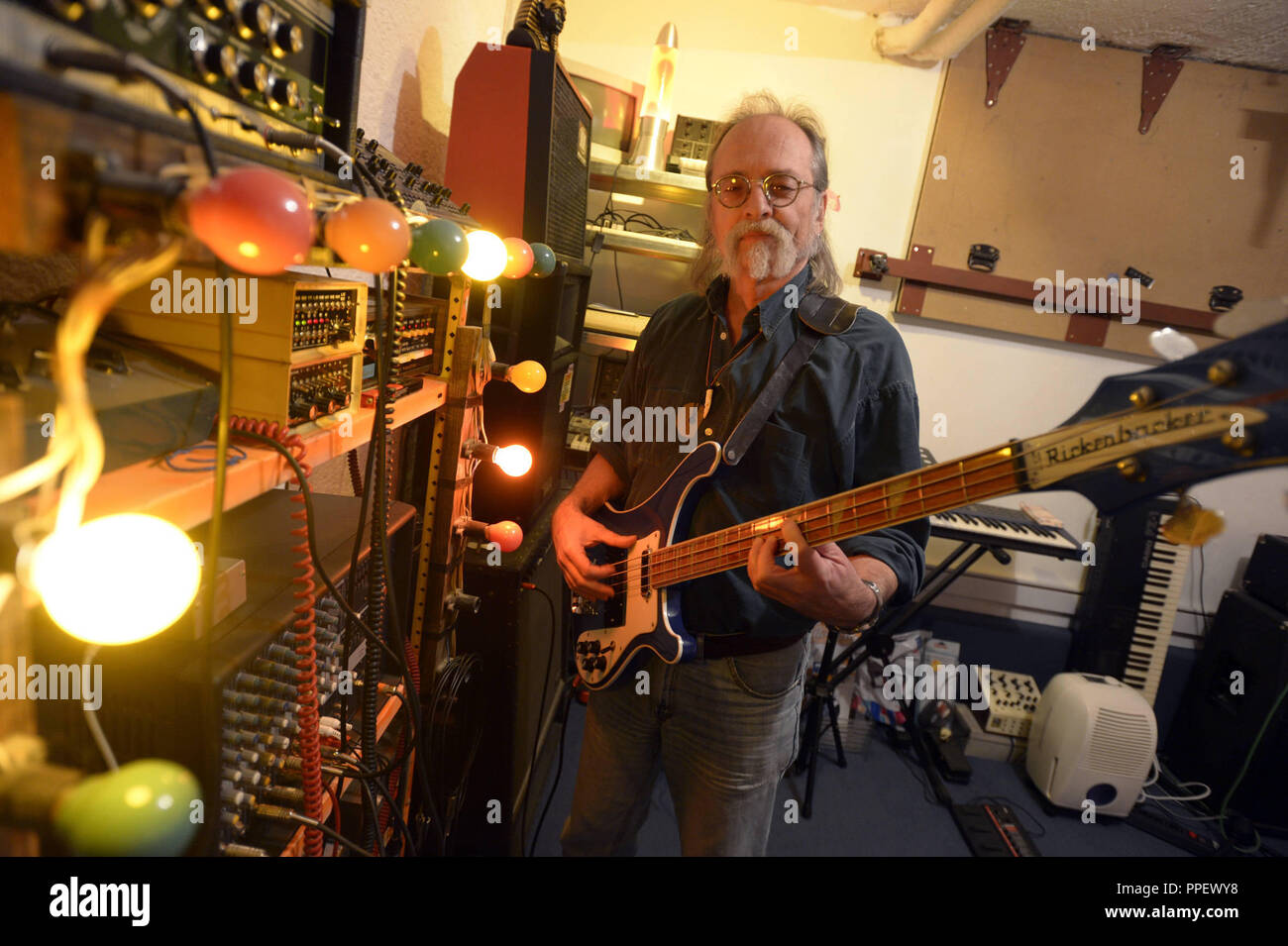 The composer, musician and painter Peter Frohmader, one of the first people who made Krautrock electronic music with homemade instruments in Germany, with a Rickenbacker electric bass guitar in his home in Munich Harlaching. Stock Photo