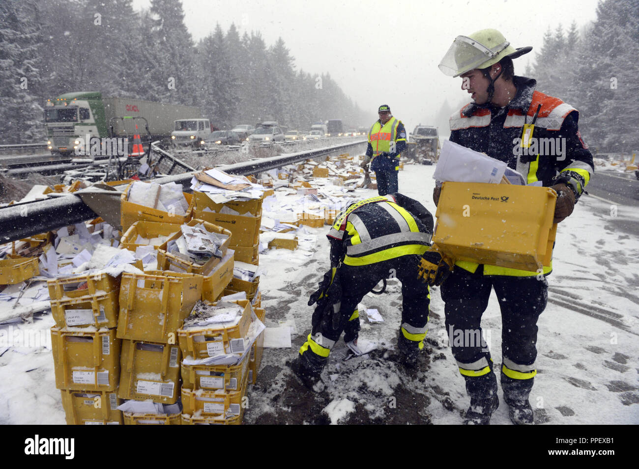 Truck accident on the A8 towards Salzburg: a mail truck with parcels and letters skidded, crashed and the entire load scattered over the A8. Towards Salzburg there is a total barrier, the fire department of Brunnthal and Hofolding are on site, alerting the THW to collect the mail soaked from snow. Stock Photo