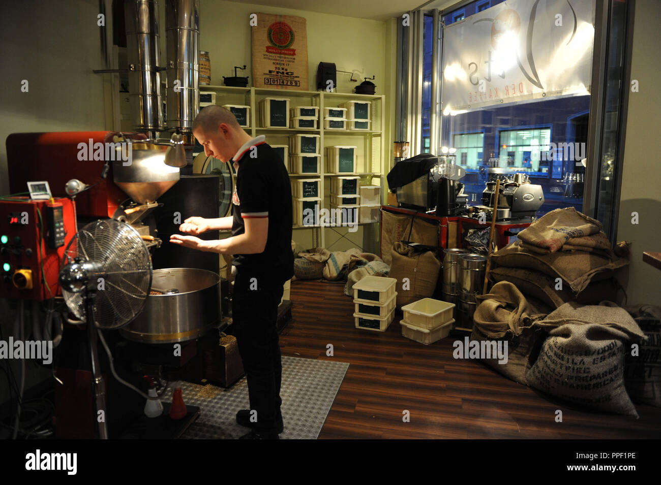 Man roasting coffee at the coffee roastery Vits in the Rumfordstrasse, Munich, Germany Stock Photo