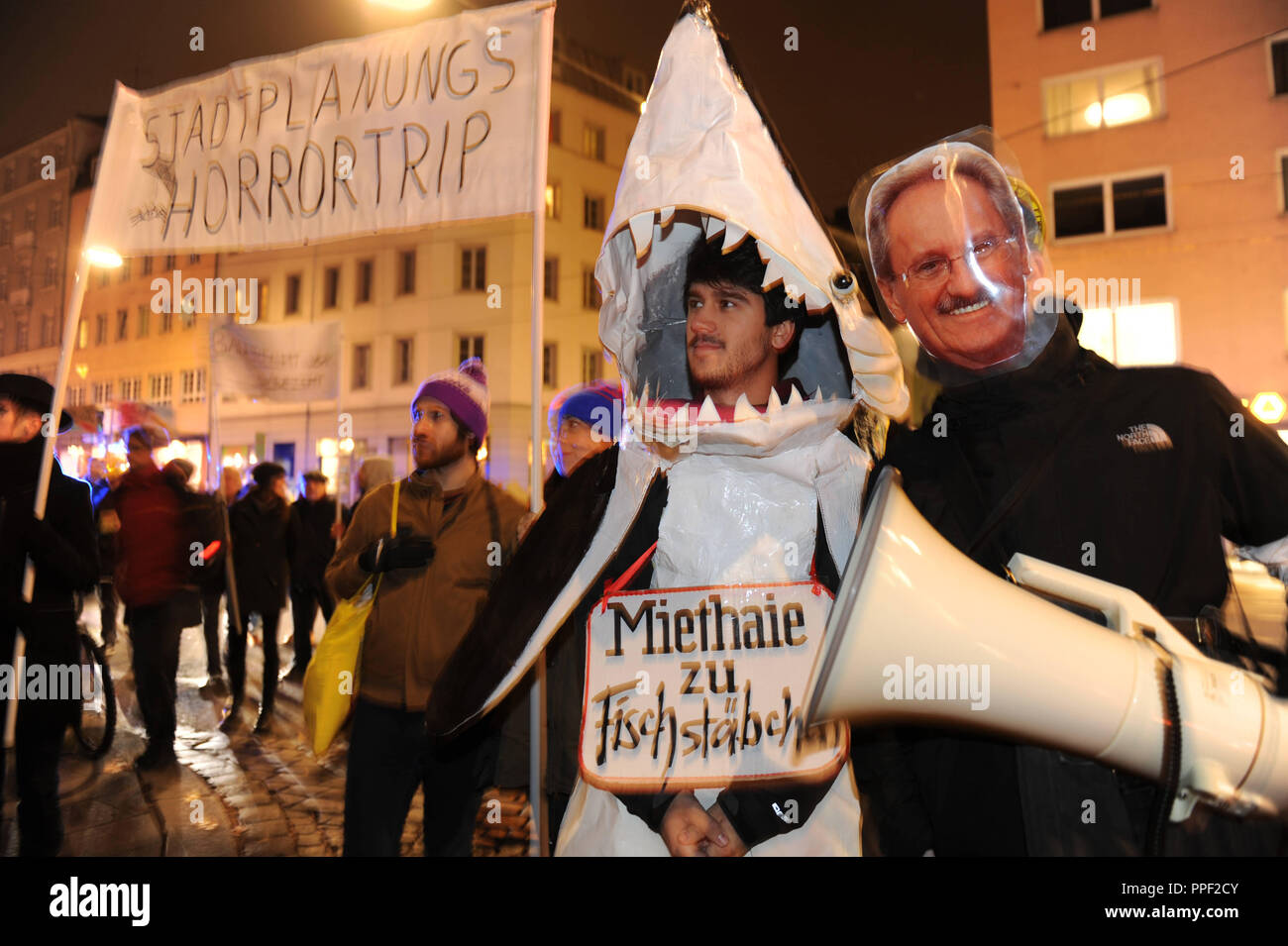 Demonstrators are protesting against the transformation of the city to a ghetto of the rich at a 'Stadtplanung-Horrortrip' event. Among other things, it is against luxury apartments like the Glockenbach suites. A banner bears the inscription Miethaie zu Fischstäbchen' (chop the landlord sharks into fish sticks), a demonstrator carries a portrait of Christian Ude. Stock Photo