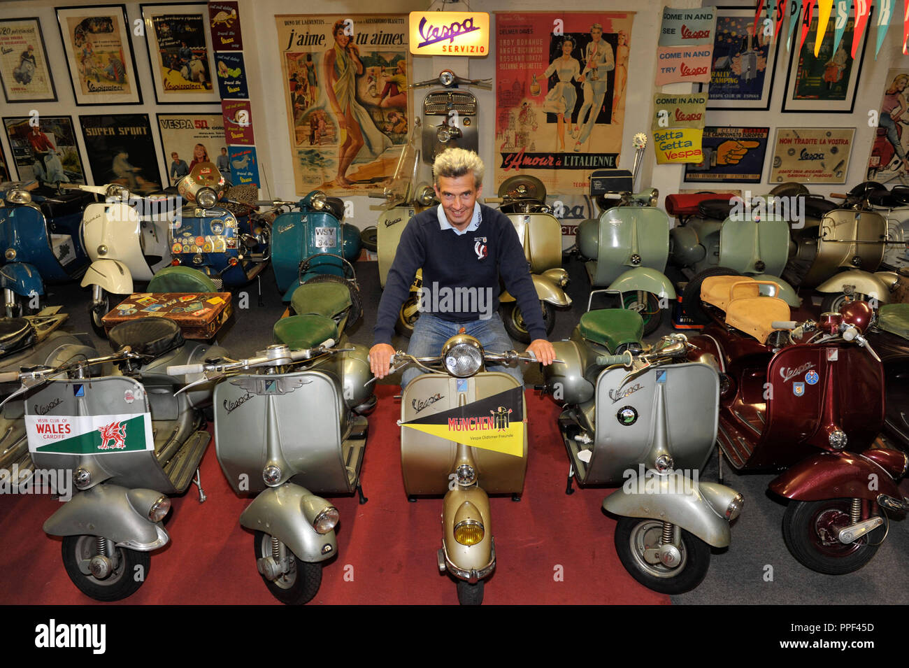 The Vespa collector and expert Robin Davy has set up a private Vespa museum  in the garage. The picture shows him surrounded by his scooters Stock Photo  - Alamy