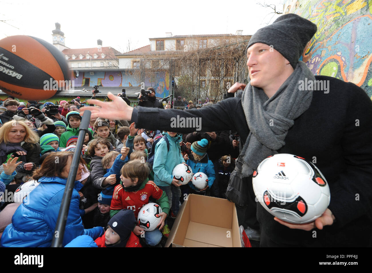 Bastian Schweinsteiger, football player at FC Bayern Munich, distributes 100 balls to children at an event for the saving of the sports ground at the community center Glockenbachwerkstatt in the Blumenstrasse. Stock Photo