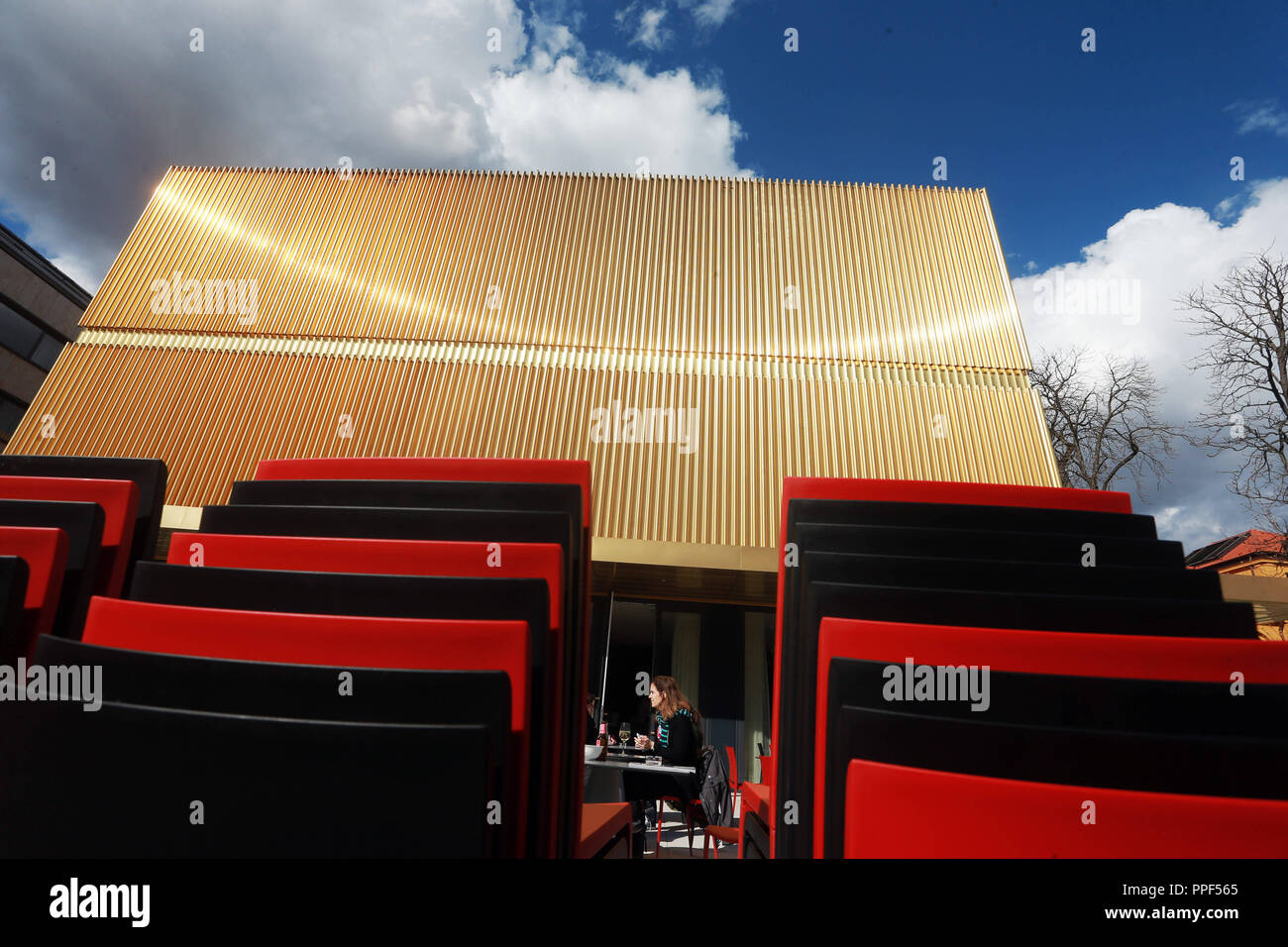 The terrace of the museum restaurant 'Ella' in front of the extension of the Lenbachhaus with its shining golden facade. Stock Photo