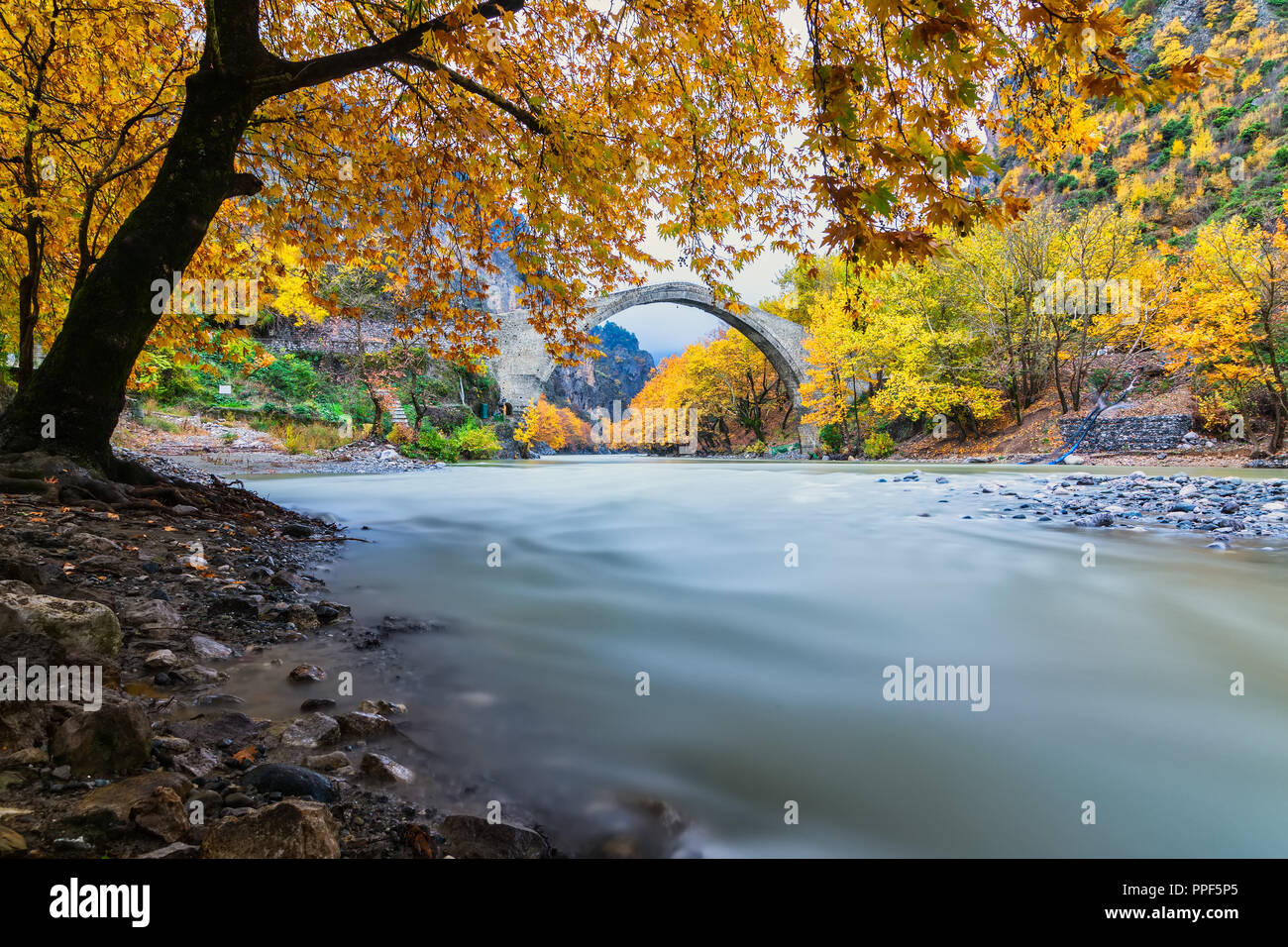 Old stone bridge in Konitsa and Aoos River an autumn day,Epirus, Western Greece. (Soft Focus) Long exposure using ND filter Stock Photo