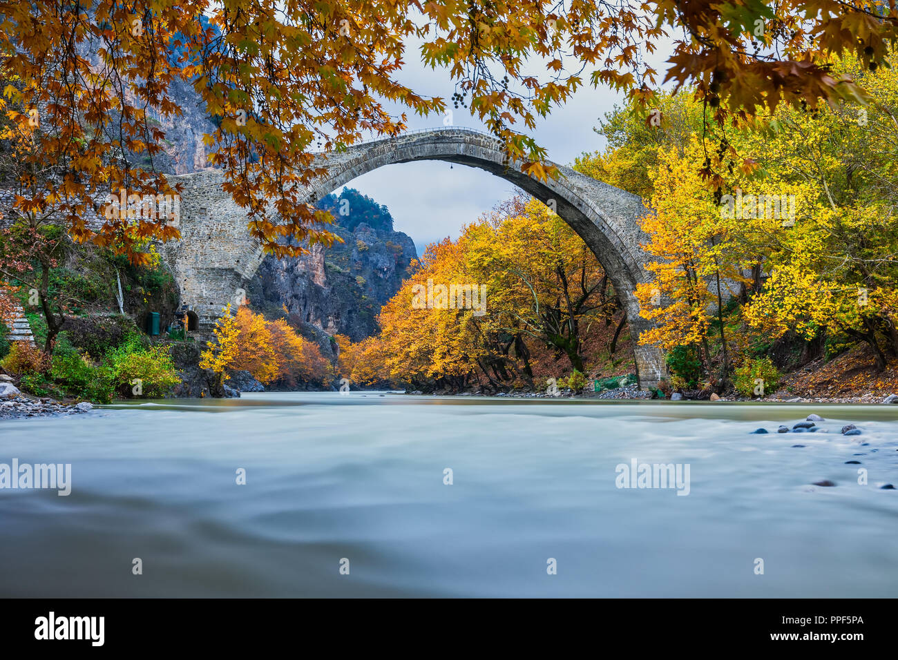 Old stone bridge in Konitsa and Aoos River an autumn day,Epirus, Western Greece. (Soft Focus) Long exposure using ND filter Stock Photo