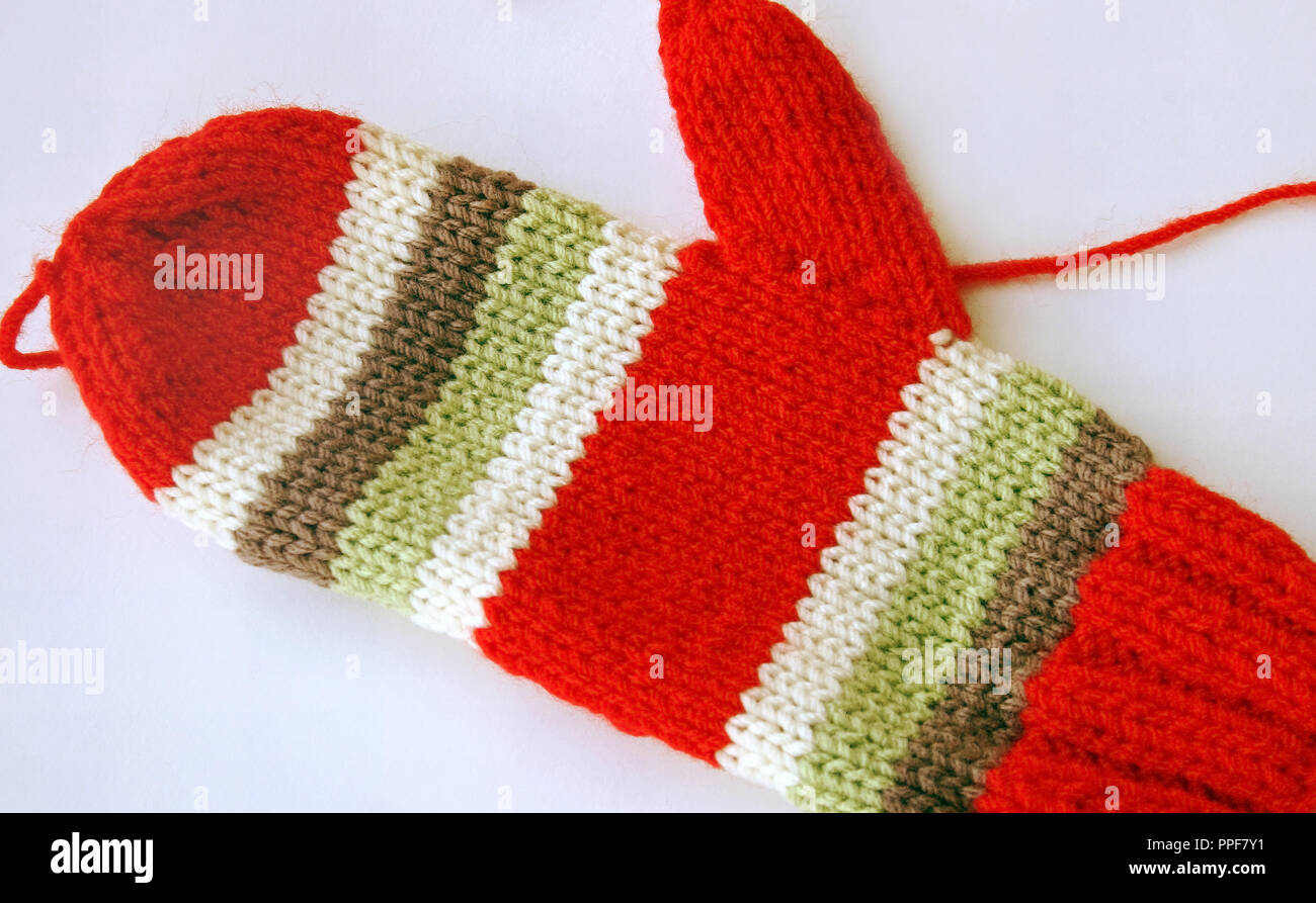 Bright and colorful handmade knitted mitten in red and green and white