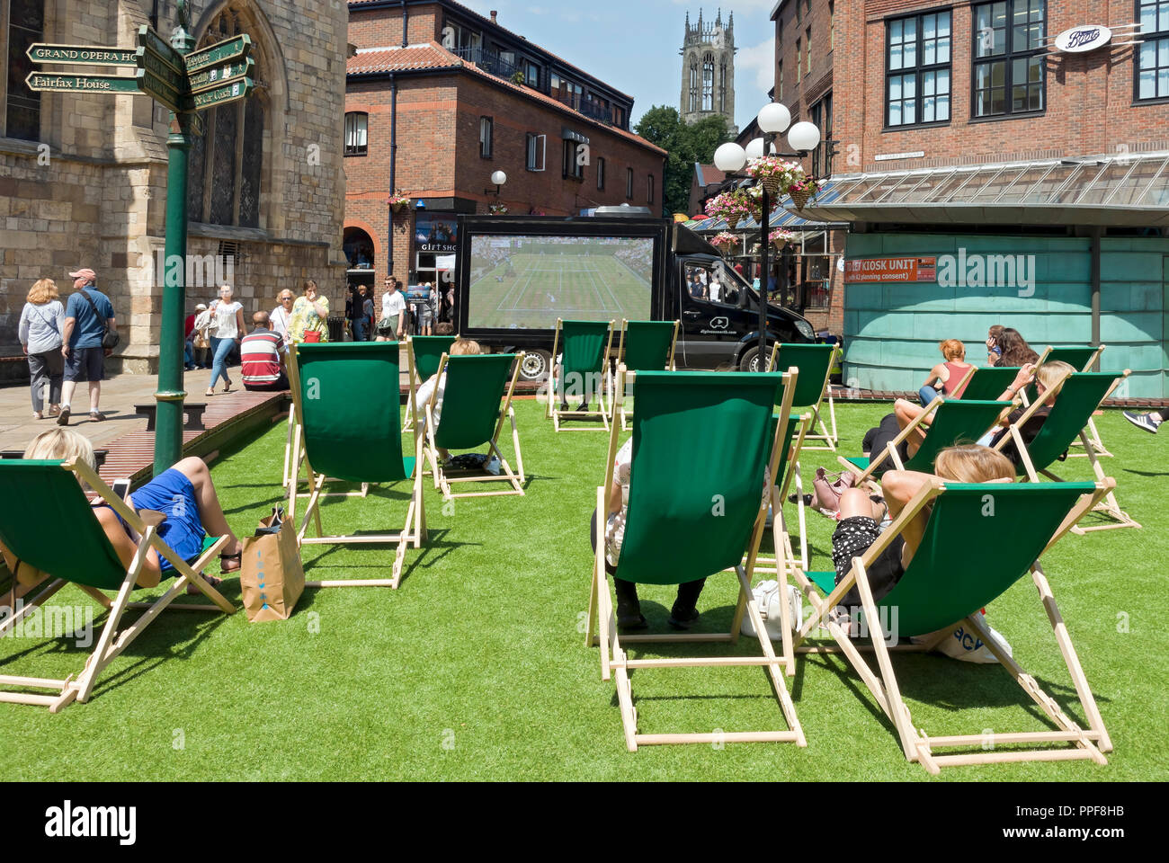 People watching tennis on large screen outside outdoors in summer Coppergate York North Yorkshire England UK United Kingdom GB Great Britain Stock Photo