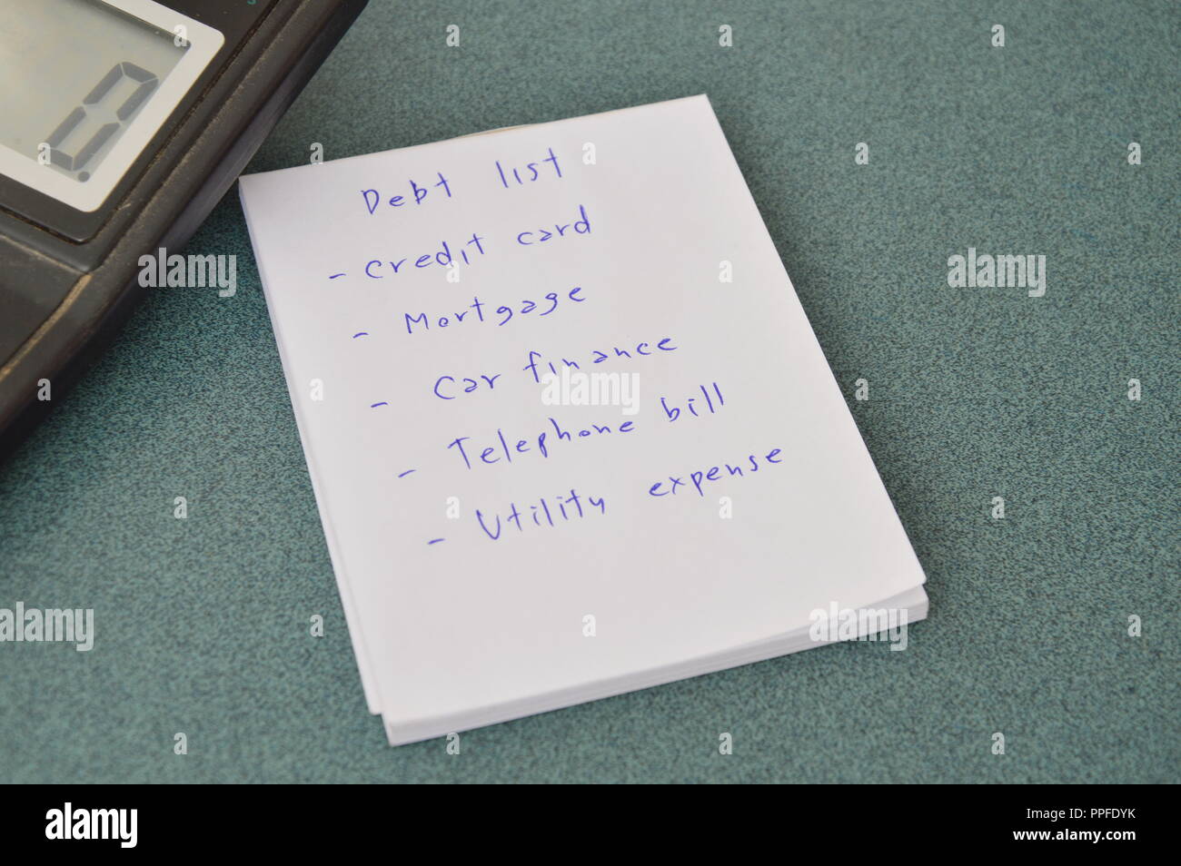 debt list and calculator on table Stock Photo
