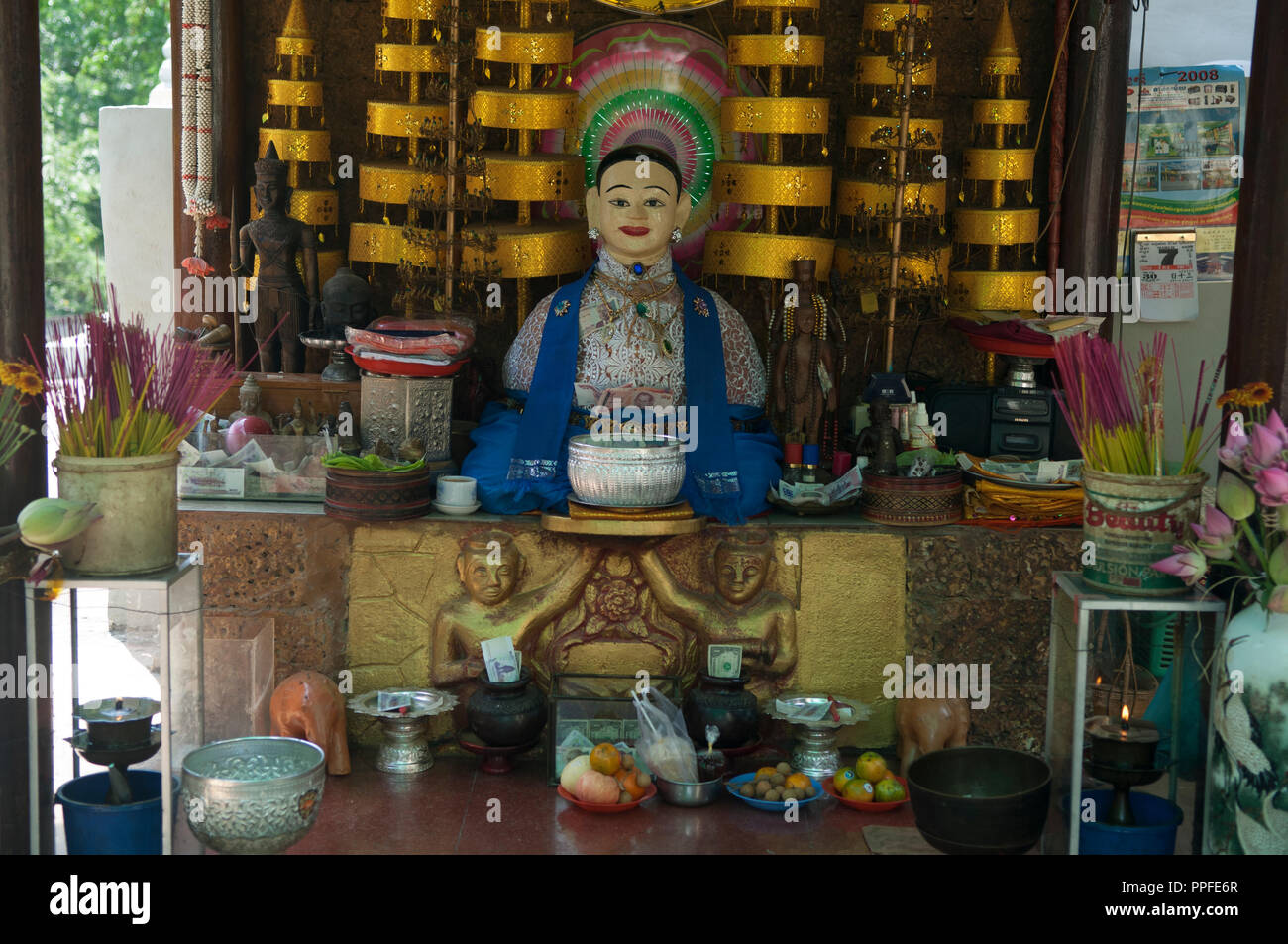 Buddhist altar with prayer wheels, offerings, lotus flowers and insense, Phnom Penh, Cambodia