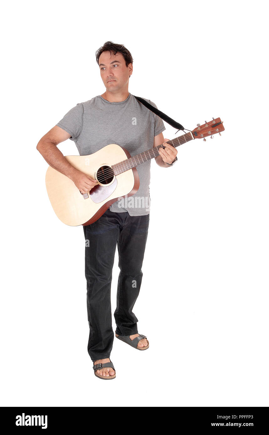 A young handsome man standing with his guitar and playing a song in jeans  and t-shirt, isolated for white background Stock Photo - Alamy
