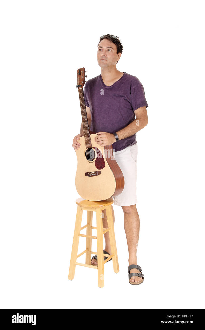 A handsome young man standing in a burgundy shirt holding his guitar ...