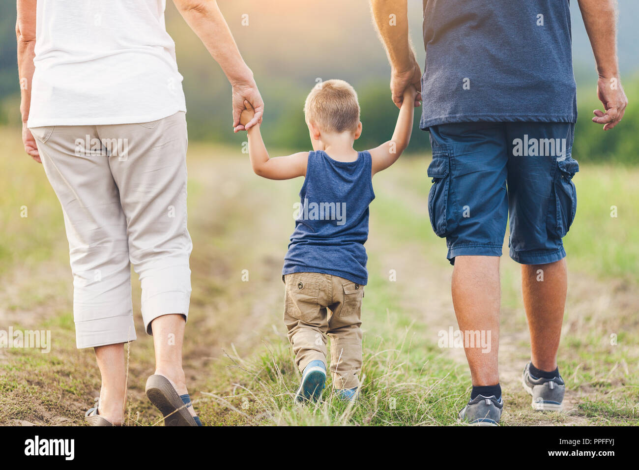 Happy grandparents on a walk outside with their grandchild Stock Photo