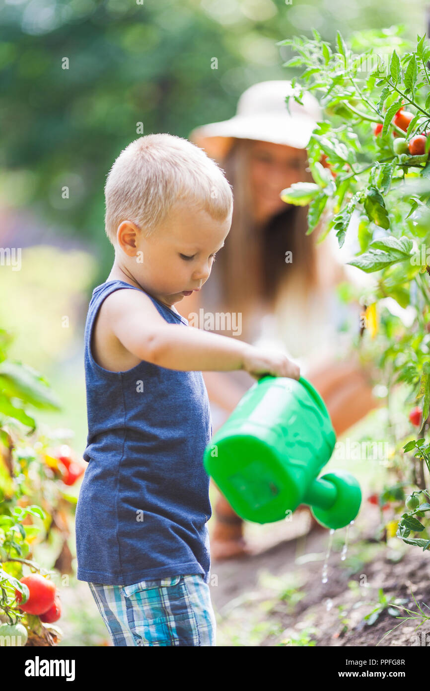 Cute toddler helphing out mom in the garden Stock Photo - Alamy
