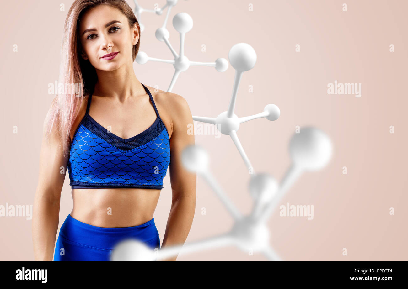 Athletic fitness woman standing near white molecule chain. Stock Photo