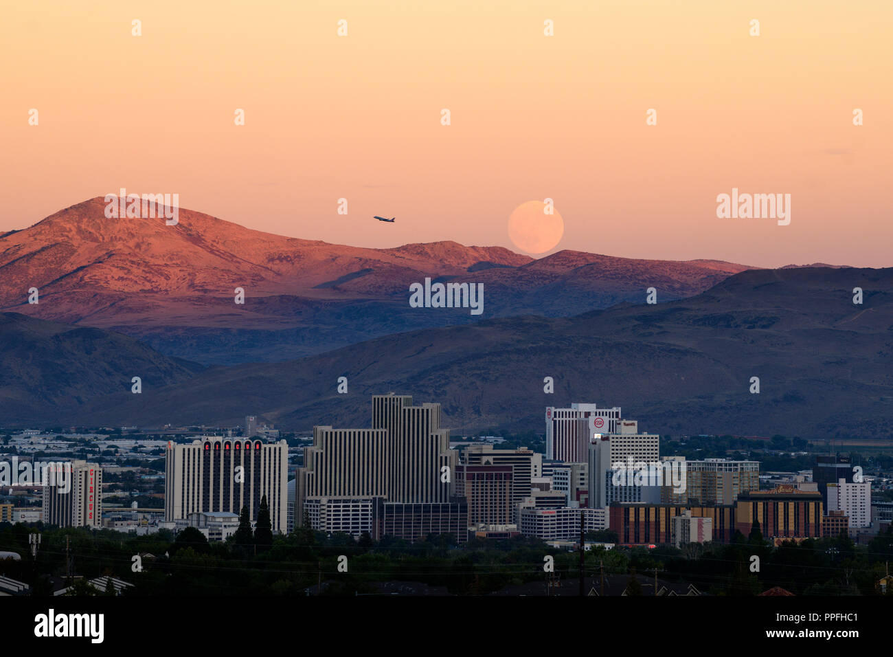 Full Harvest Moon rise over downtown Reno skyline just after the fall