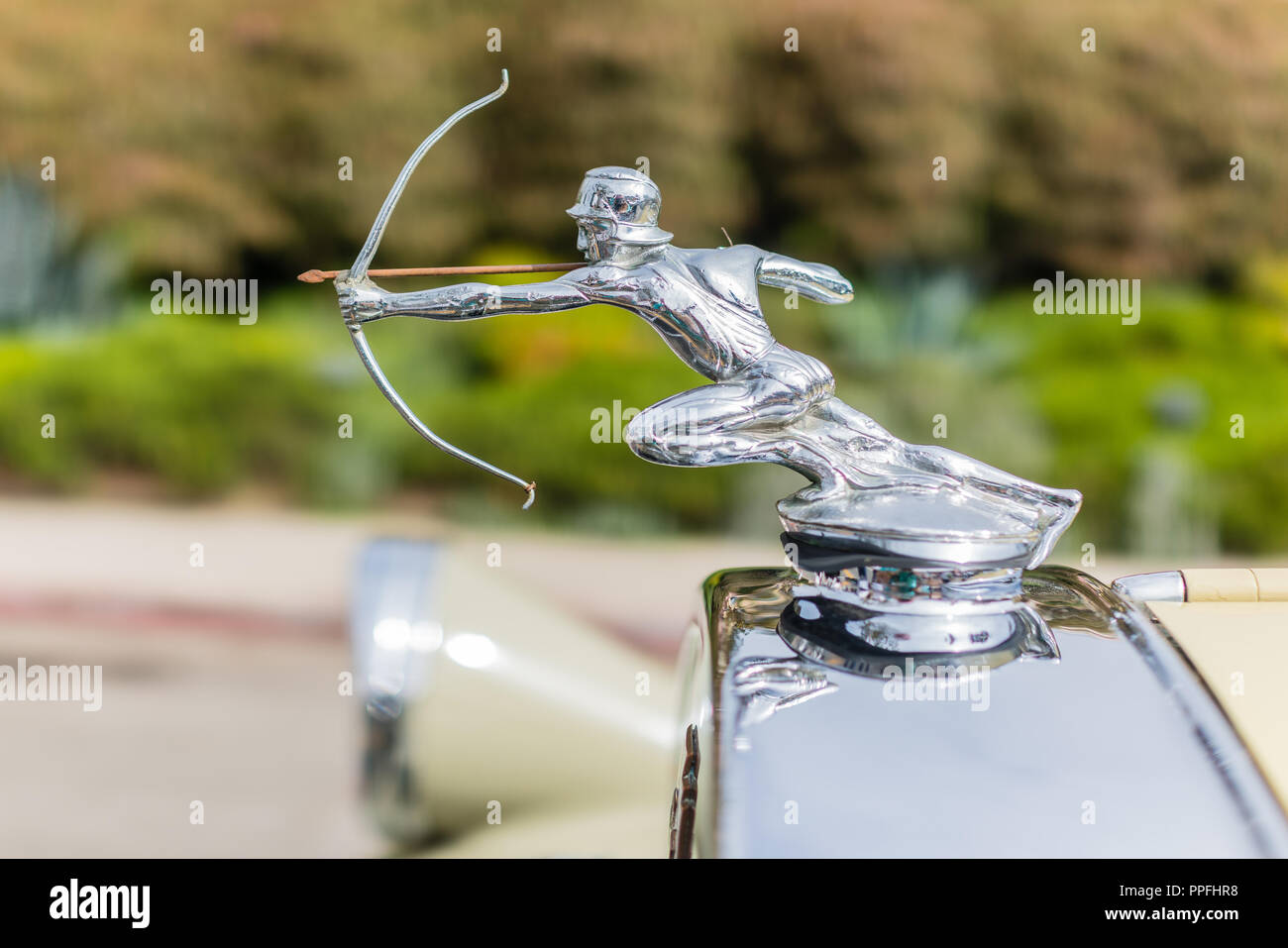 Close-up view of classic Pierce Arrow automobile hood ornament featuring a statue of a male with a bow and arrow with the bow pulled tight ready to re Stock Photo