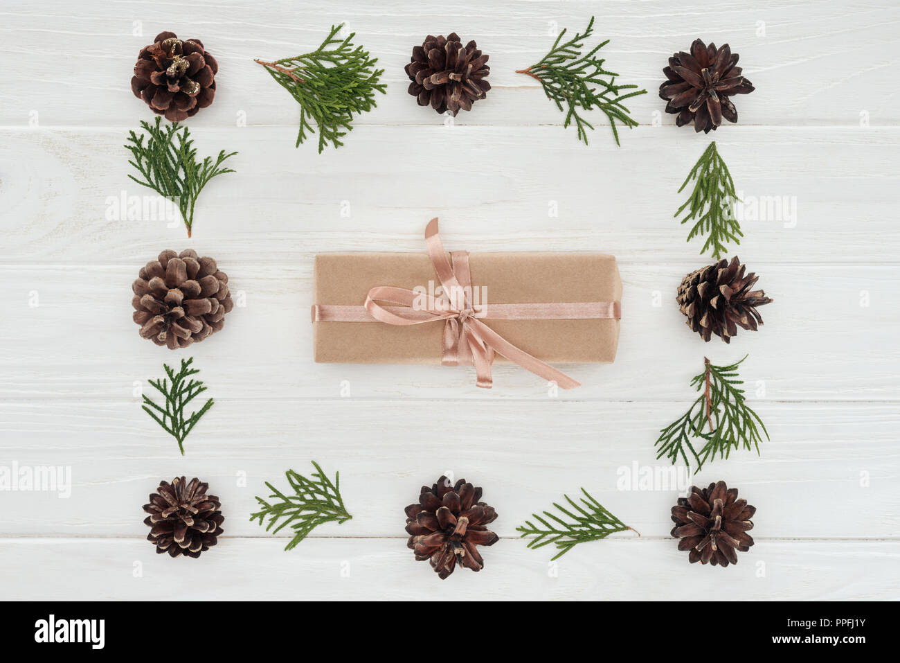top view of christmas present and beautiful evergreen coniferous twigs with pine cones Stock Photo