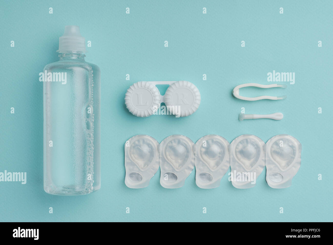 flat lay with sterile liquid in bottle, tweezers and containers for