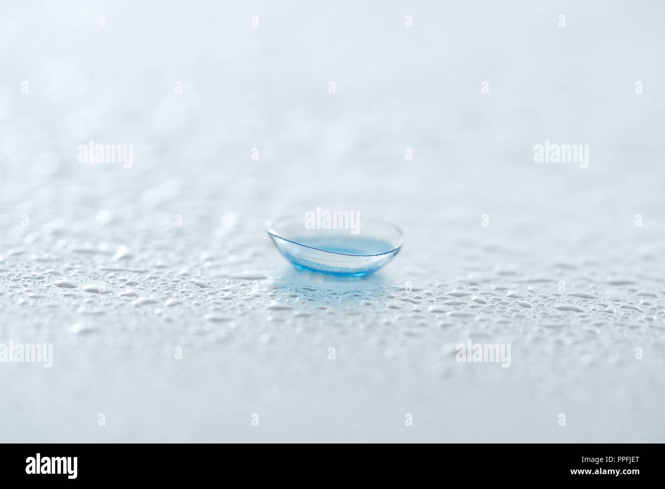 close up view of contact lense on white background with water drops Stock Photo