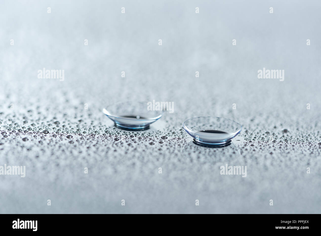close up view of contact lenses on background with water drops Stock Photo