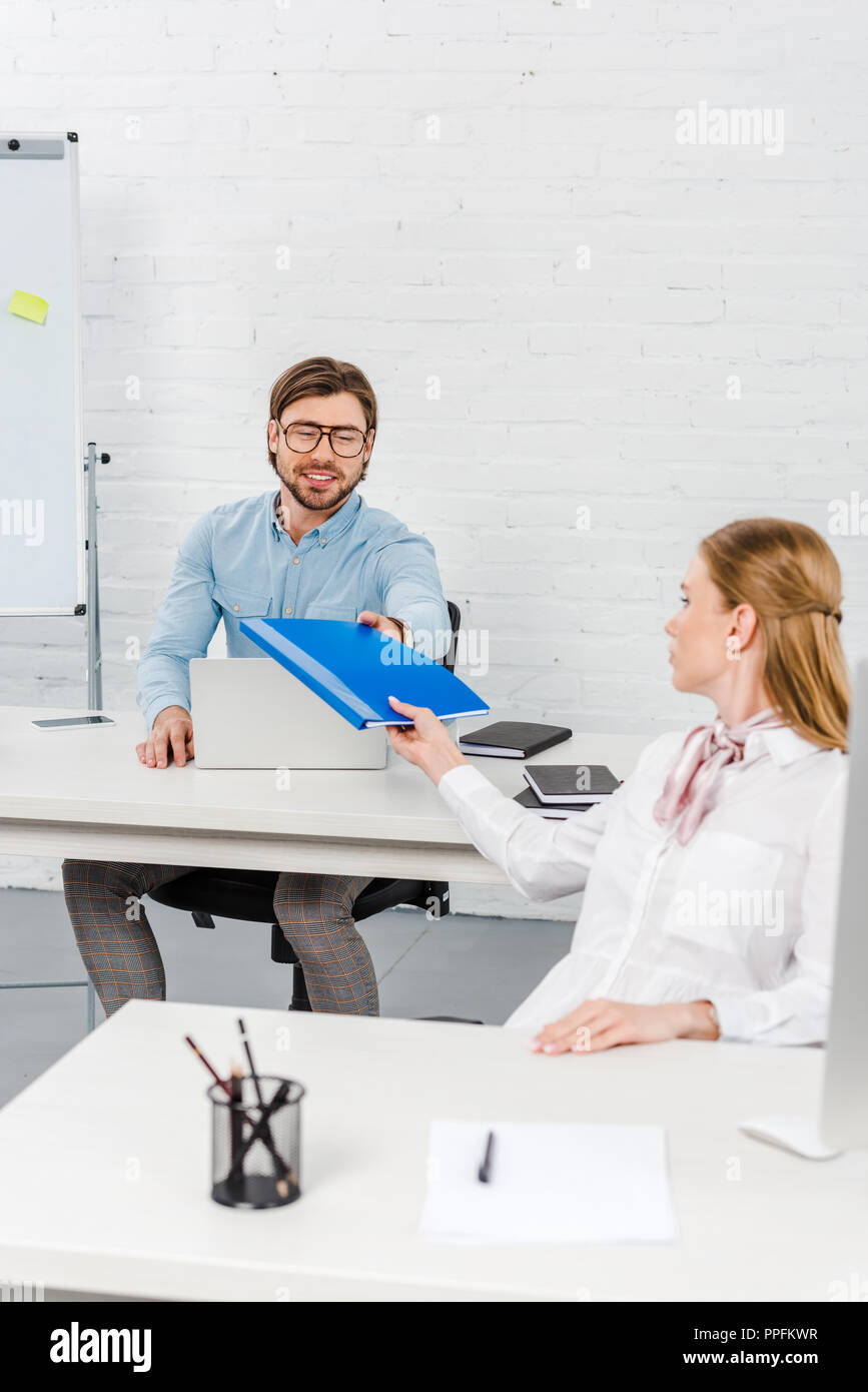 managers passing folder with documents at modern office Stock Photo - Alamy