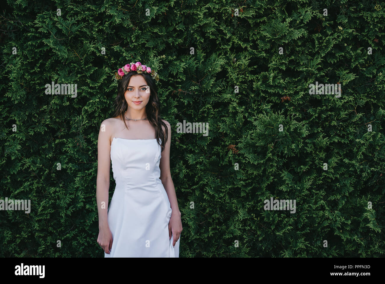 attractive bride posing in traditional white wedding dress and flower ...