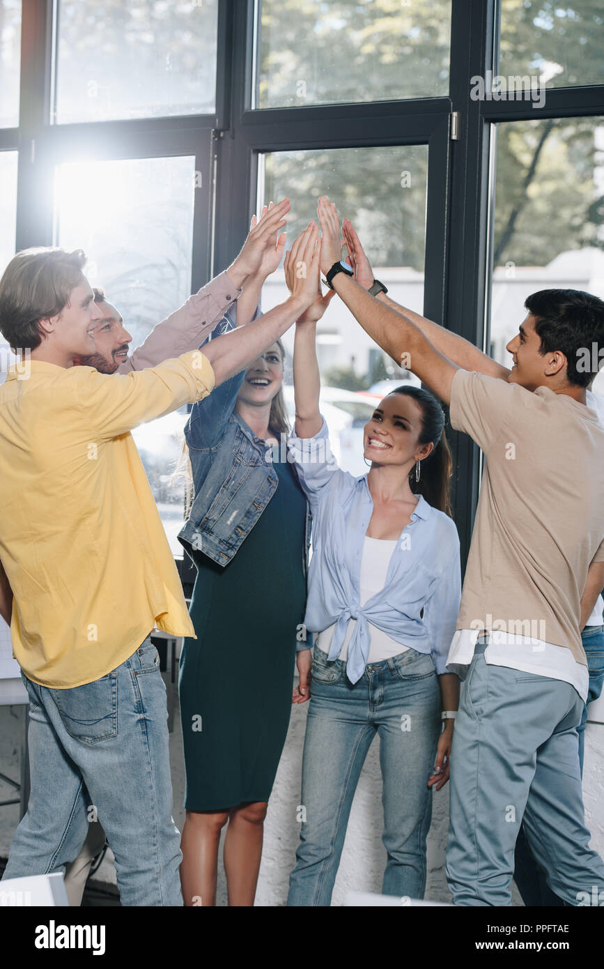 businesspeople celebrating success and giving high five in office Stock ...