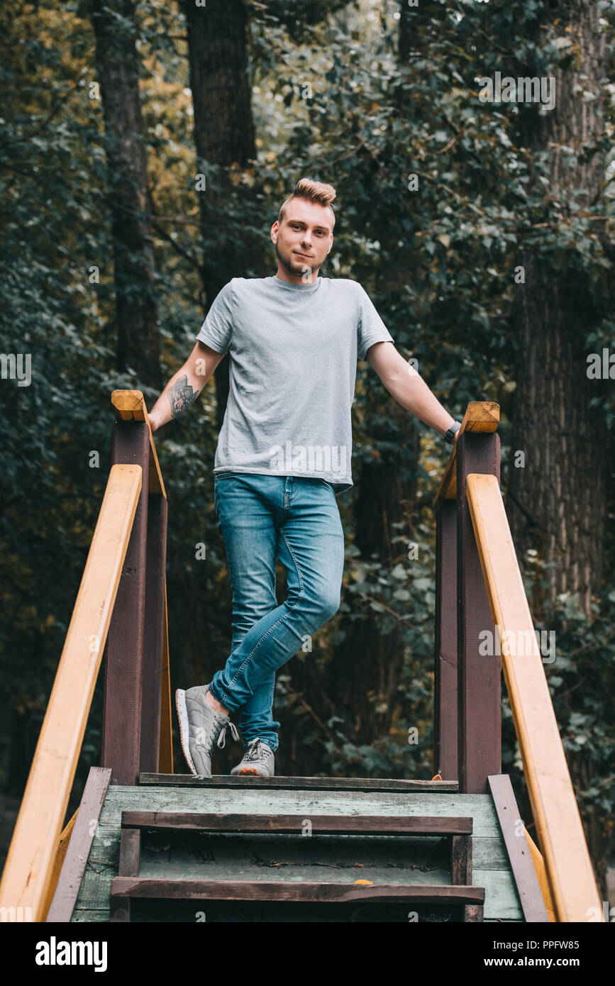 handsome man posing on stairs in park and looking at camera Stock Photo ...