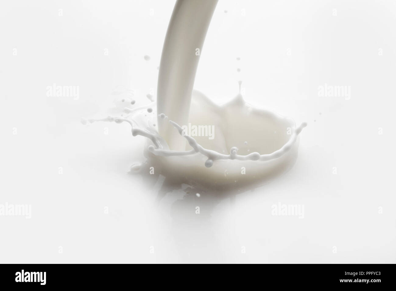 Pouring milk splash on white background macro Stock Photo - Alamy