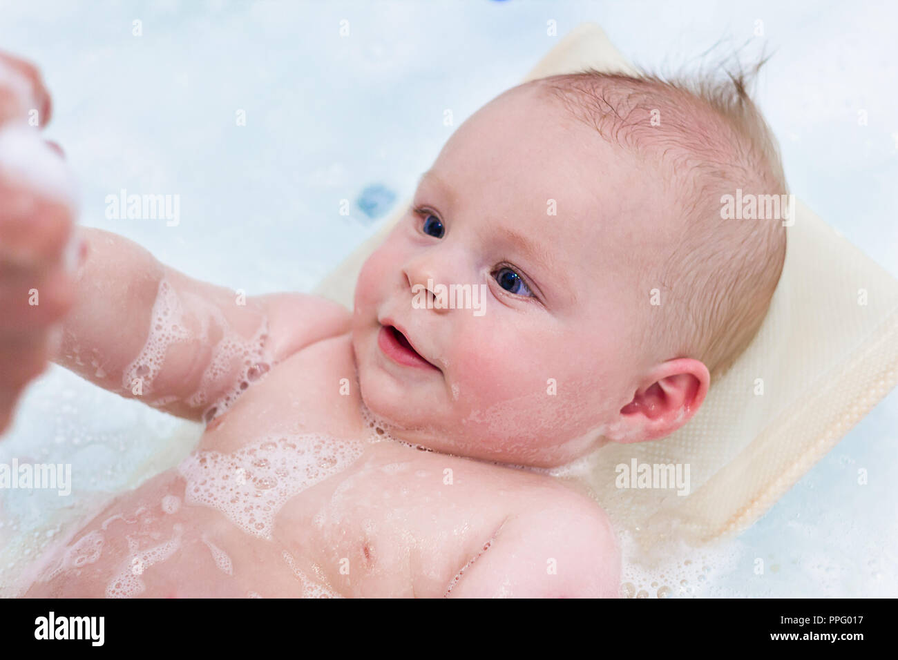 6 month baby boy taking a bath. Little child in a bathtub. Infant