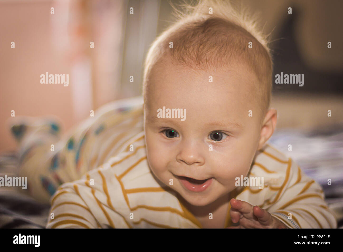 Portrait of a expressive happy baby, holds head up. baby development concept photo, lifestyle. Stock Photo