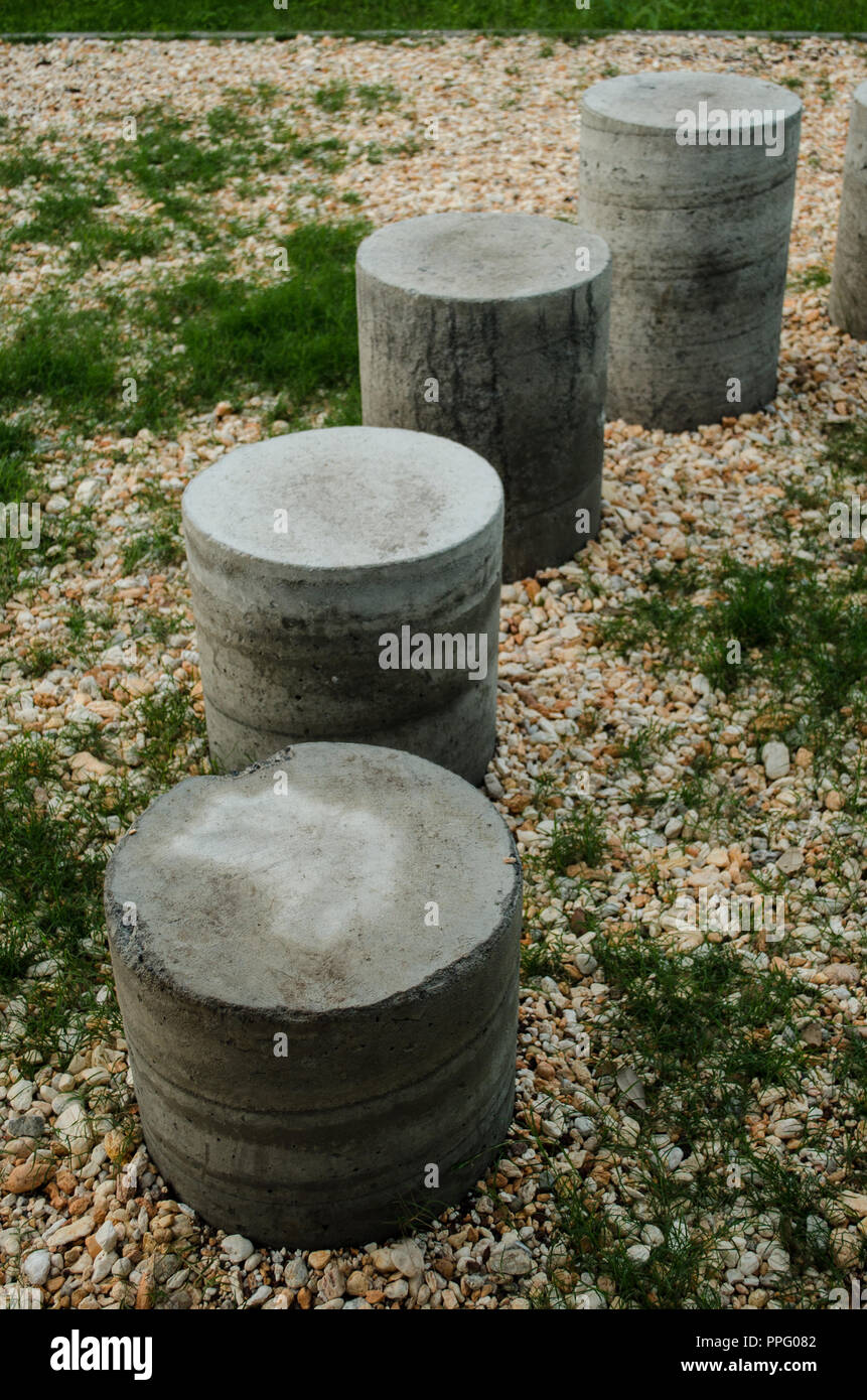 Cement cylinders in the form of stairs, surrounded by yellowish stones