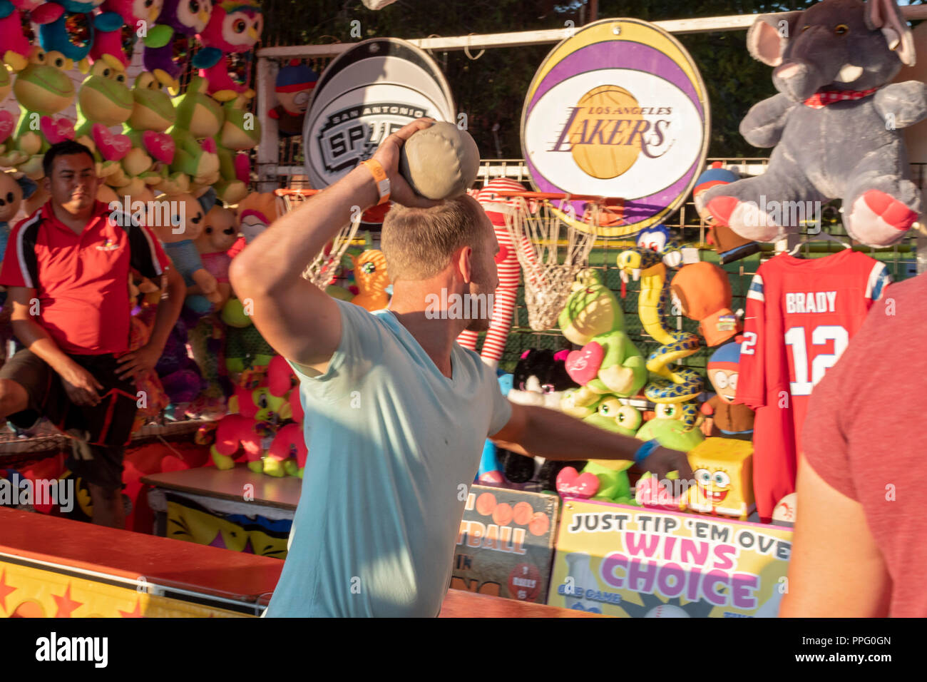 Wheat Ridge, Colorado - A man tries hard to win a prize in a carnival game during the annual Carnation Festival. The festival features food and entert Stock Photo