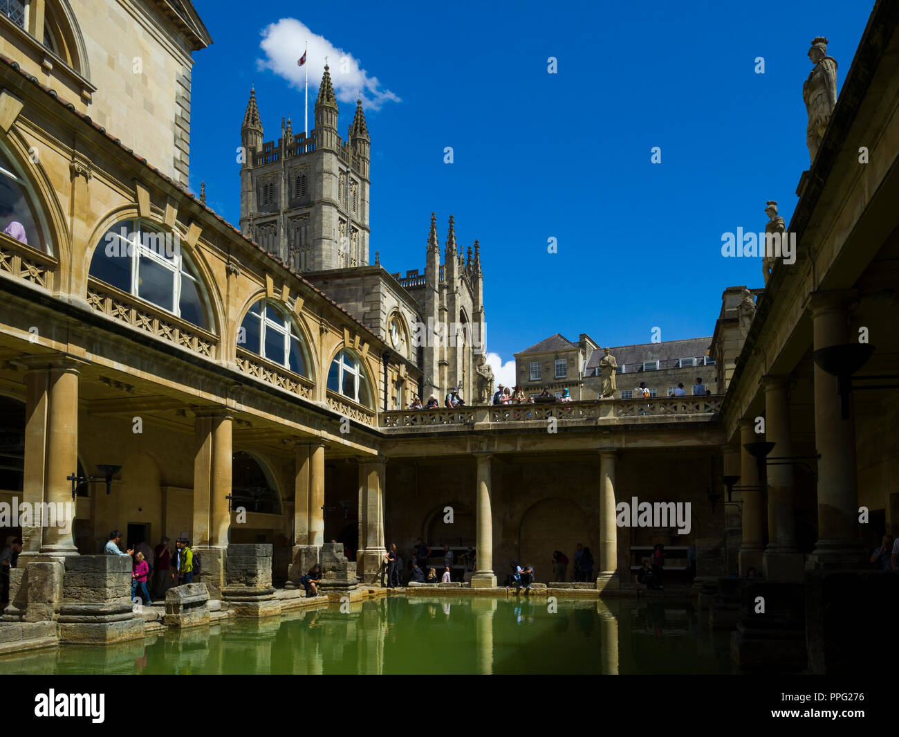 Visitors exploring the historic Roman Baths with Bath Abbey towering above, Bath, Somerset