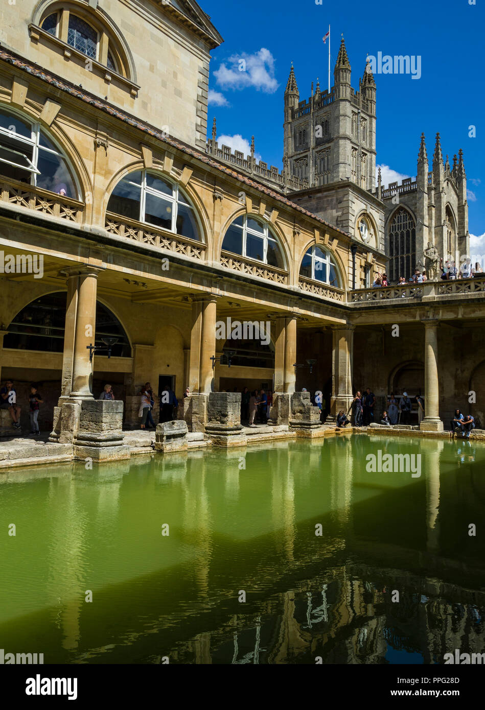 Visitors exploring the historic Roman Baths with Bath Abbey towering