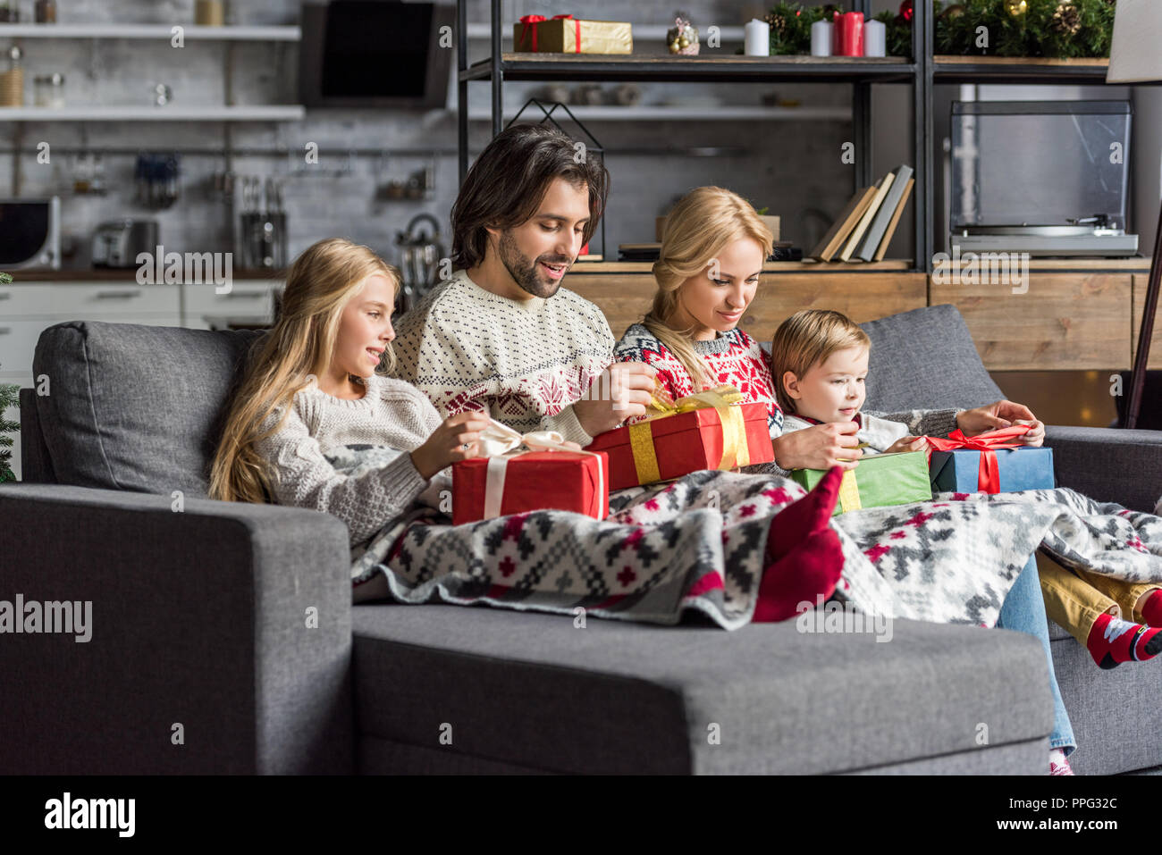 happy family with two kids opening christmas presents together Stock Photo