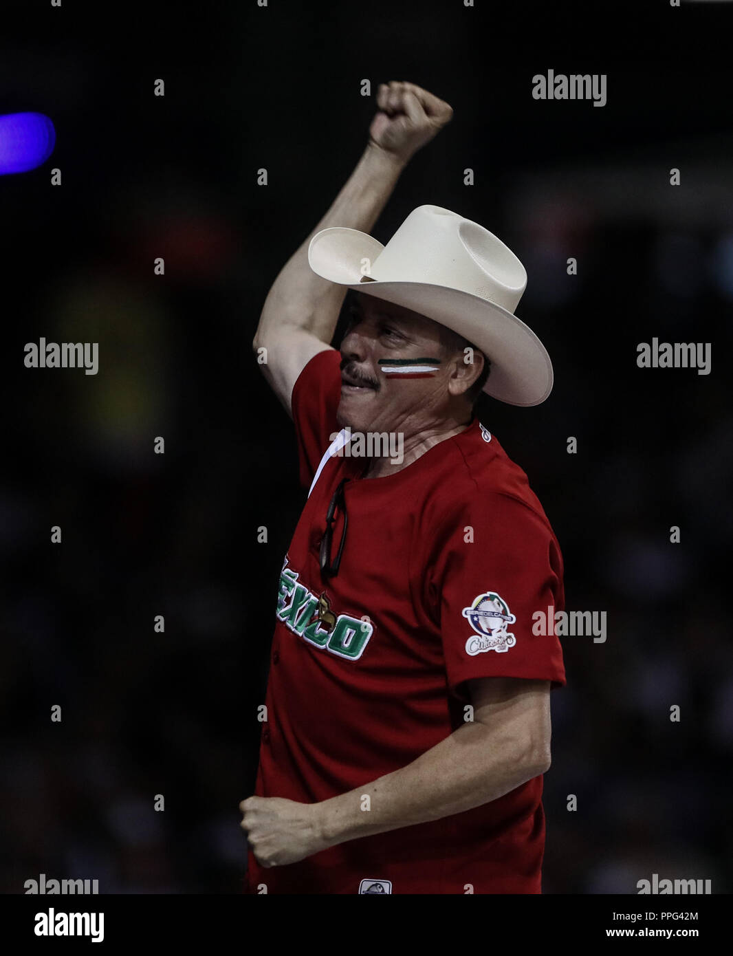 Aficionado que viste de sombrero vaquero y jersey de Mexico anima a la