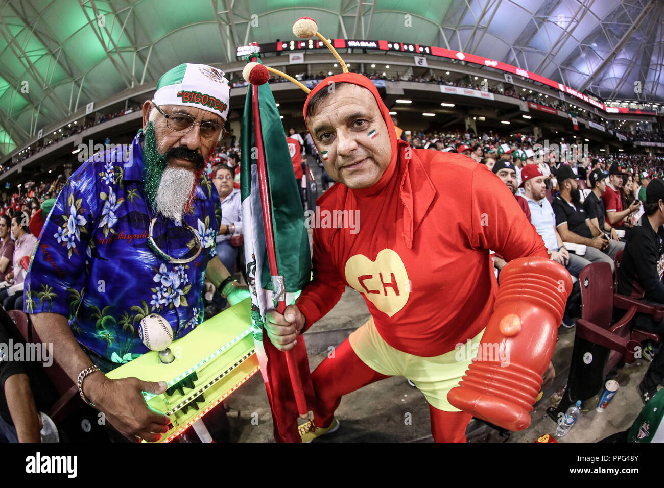 Un hombre viste de el capulín colorado es acompañado de un ¨Matakero¨ en apoyo a Mexico , durante el segundo partido semifinal de la Serie del Caribe Stock Photo