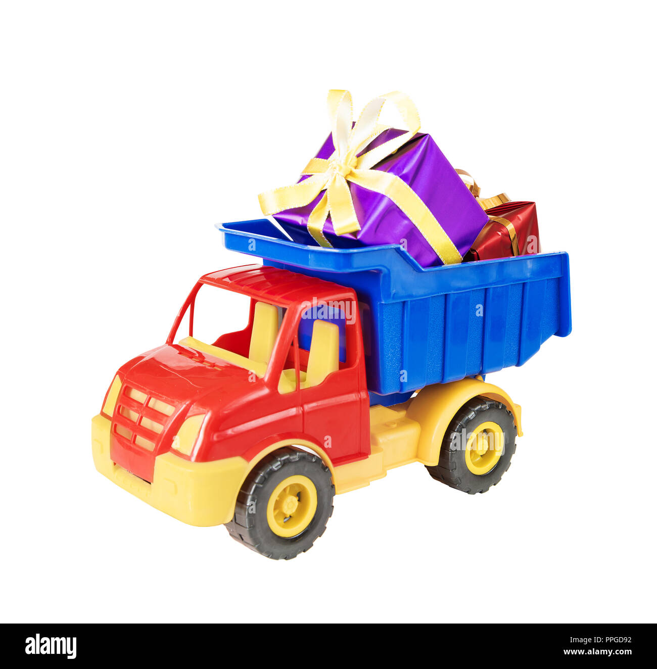 Multicolored plastic toy truck carries gift boxes tied with decorative ribbons in body,  isolated on white background Stock Photo