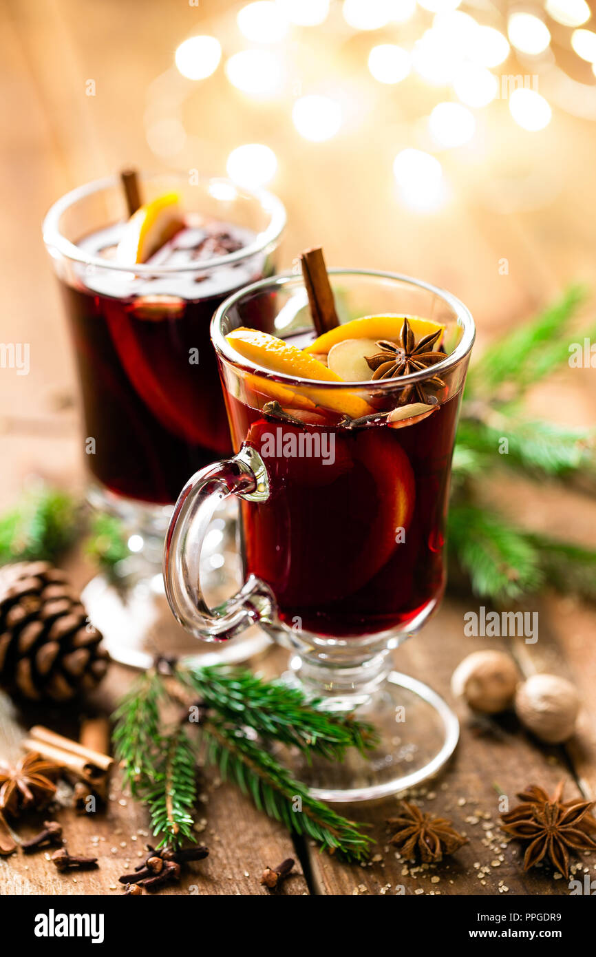 Christmas mulled red wine with spices and oranges on a wooden rustic table. Traditional hot drink at Christmas Stock Photo