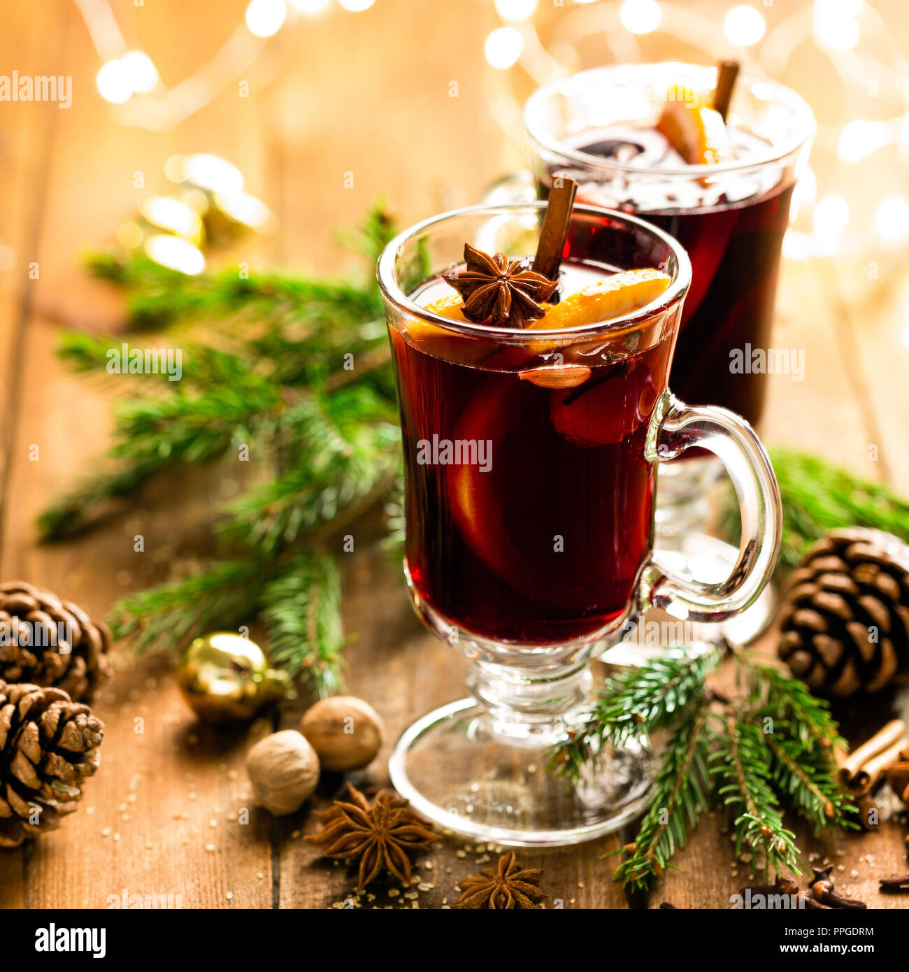 Christmas mulled red wine with spices and oranges on a wooden rustic table. Traditional hot drink at Christmas Stock Photo