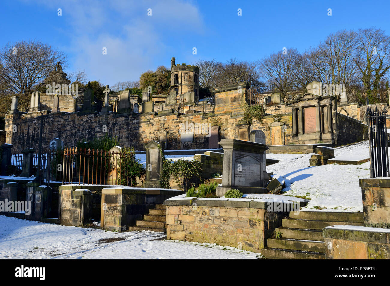 Gravestones in snow in New Calton Burial Ground, Regent Road, Edinburgh, Scotland Stock Photo