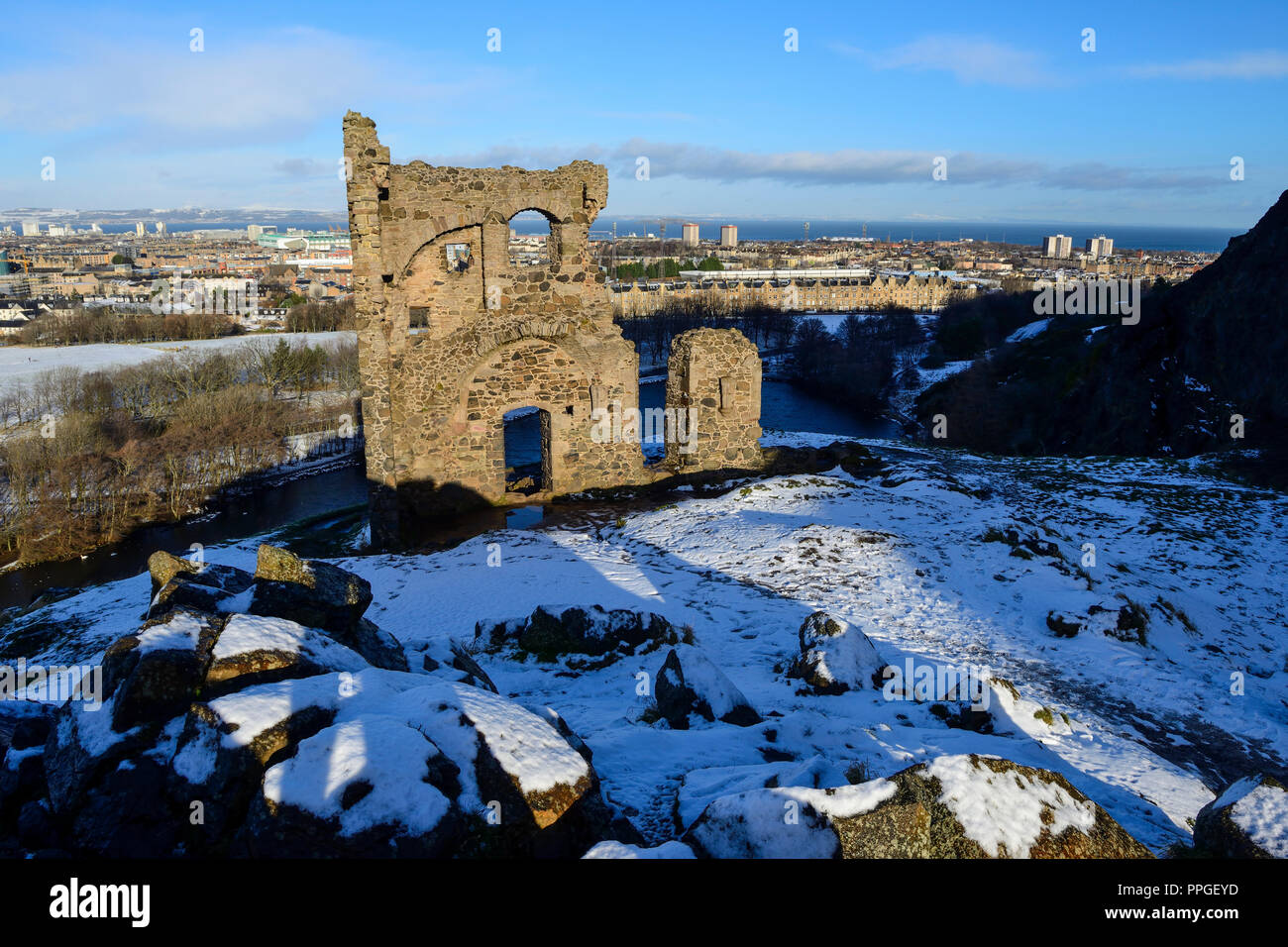 Ruins of St Anthony's Chapel in snow, with St Margaret's Loch in background, Holyrood Park, Edinburgh, Scotland Stock Photo