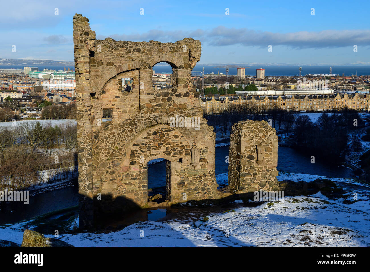 Ruins of St Anthony's Chapel in snow, with St Margaret's Loch in background, Holyrood Park, Edinburgh, Scotland Stock Photo