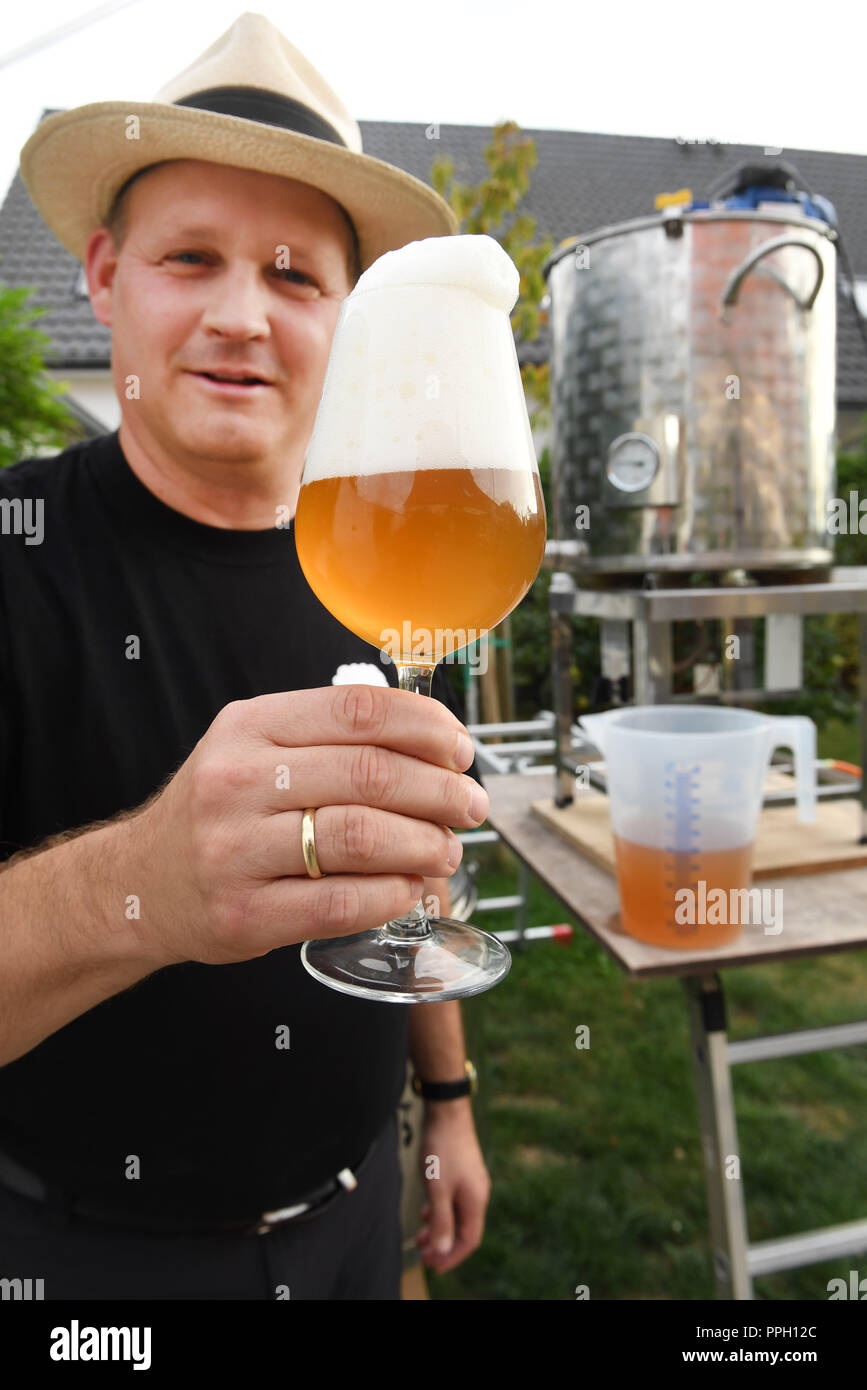 20 September 2018, Mecklenburg-Western Pomerania, Greifswald: Canned beer or industrial bottled beer hardly ever reach the glass of 46-year-old Jan Evermann from Greifswald. More and more hobby brewers brew their own beer in cellars, kitchens and garages. Evermann stores the bottles of the Eigenbräu brand - an ale or wheat - in his drinks refrigerator in the garden house. Evermann brews a maximum of 75 litres of beer with one brew access - enough for its own needs. The trend towards the craft berry has promoted this development. In championships they compete with their own creations.     (to d Stock Photo