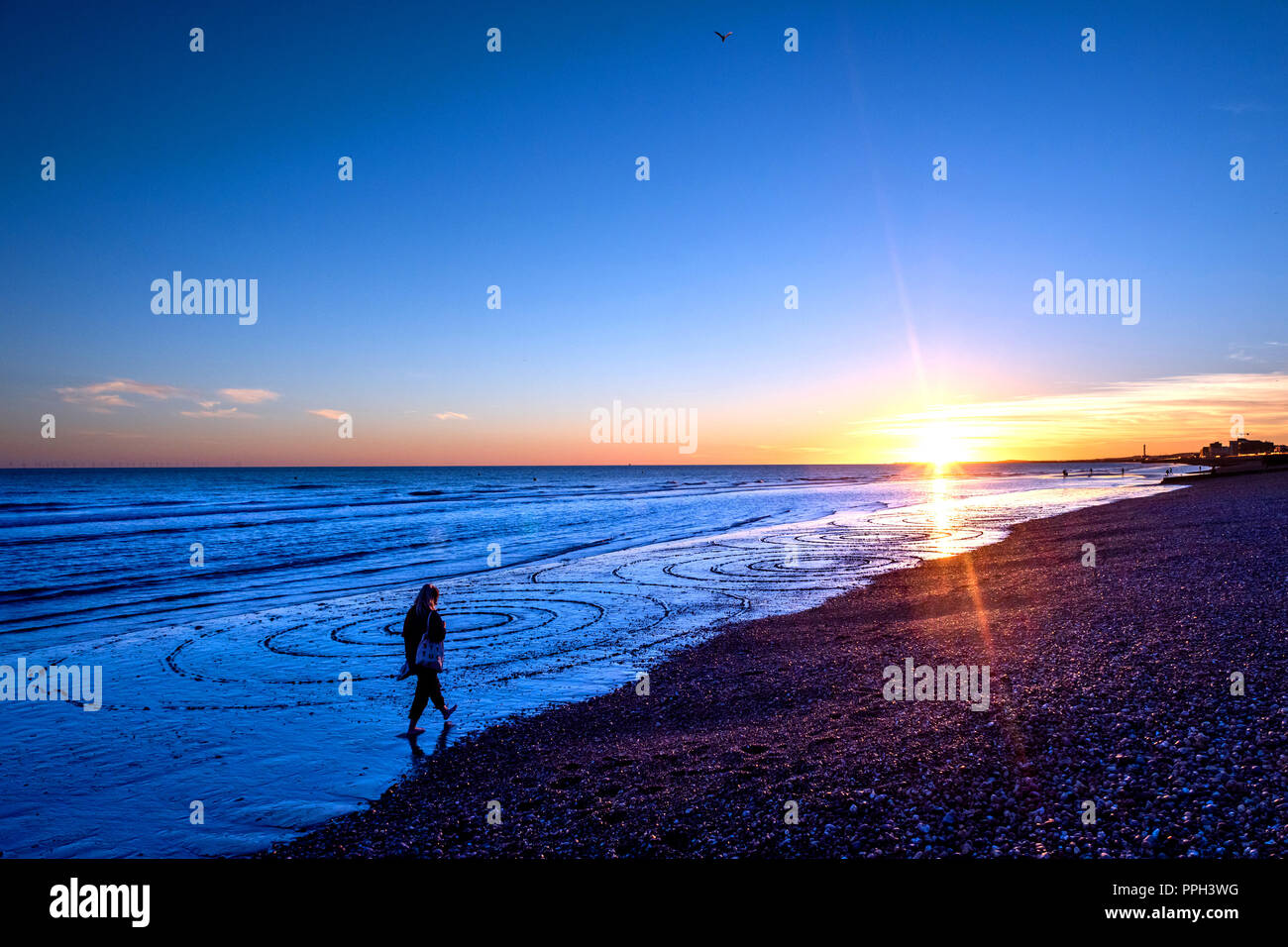 Brighton, UK. 25th Sept 2018. UK Weather: Sunset in Brighton with a particularly low tide, revealing rarely-seen sand on the city's famously pebbled beach. An even lower tide is expected this evening just before 7pm. Credit: Andrew Hasson/Alamy Live News Stock Photo