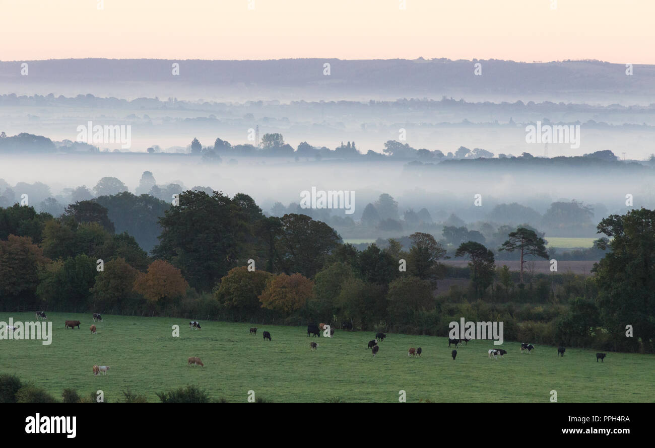Wiltshire, UK. 26th September 2018, Monkton Farleigh Wiltshire. Cooler overnight temperatures created stunning mist and fog patches that settled in the rural landscape of Monkton Farleigh and beyond into Wiltshire. The rising sun caused the fog to glow orange initially before fading to white as the track of the sun rose higher. credit: Wayne Farrell/Alamy Live News Stock Photo